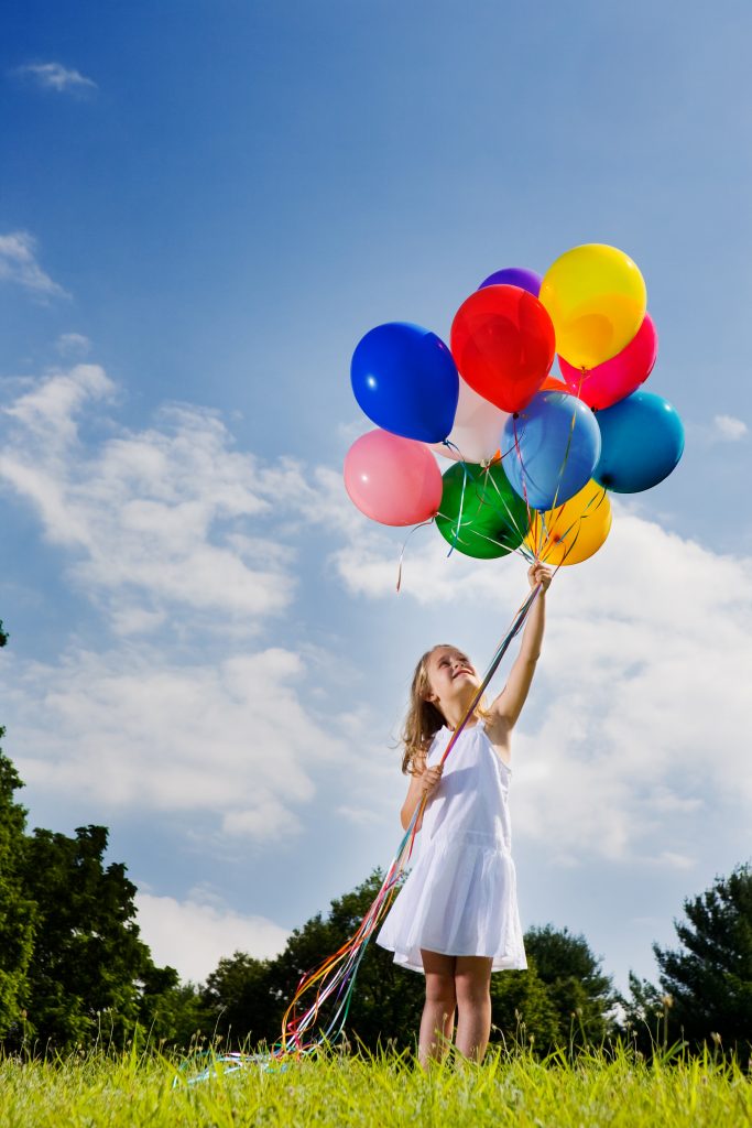 Girl holding a bunch of balloons